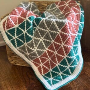 Mosaic Triangles Baby Blanket displayed in a basket
