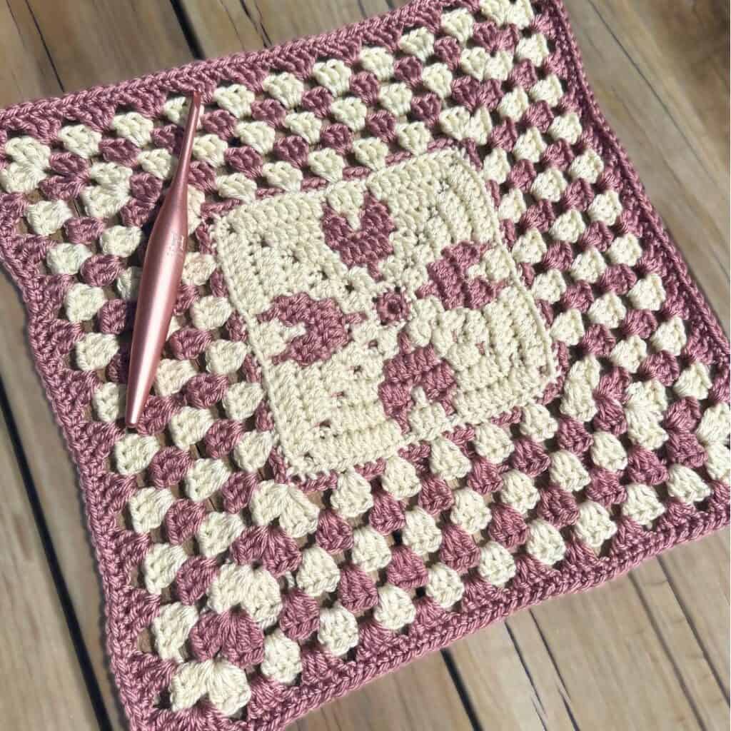 Angled view of the Mosaic Crochet Heart Granny Square with hook